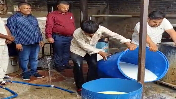 आगरा के कुकथला गांव में खाद्य सुरक्षा विभाग की टीम द्वारा अवैध डेयरी यूनिट पर छापेमारी के दौरान बरामद मिलावटी पनीर और दूषित दूध की जांच करते अधिकारी।