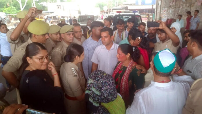 आगरा के रुनकता चौराहे पर बदहाल सड़क के विरोध में ढोल-नगाड़ों के साथ प्रदर्शन करते ग्रामीण और महिलाएं